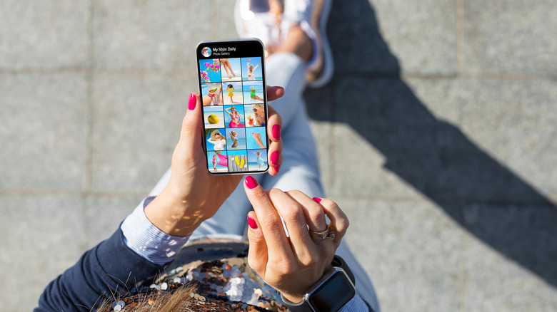 Woman holds phone with photo gallery