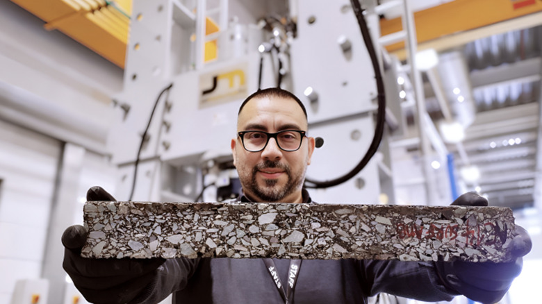 A person holding sample of a self-healing asphalt