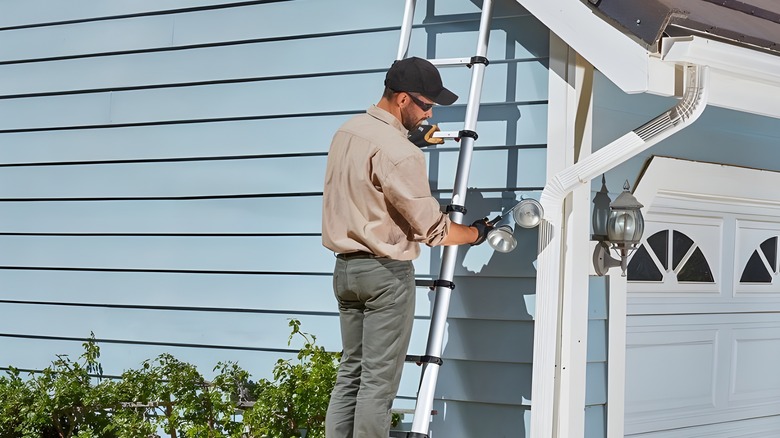 Man on ladder adjusting lights