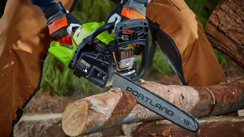 person using green portland chainsaw