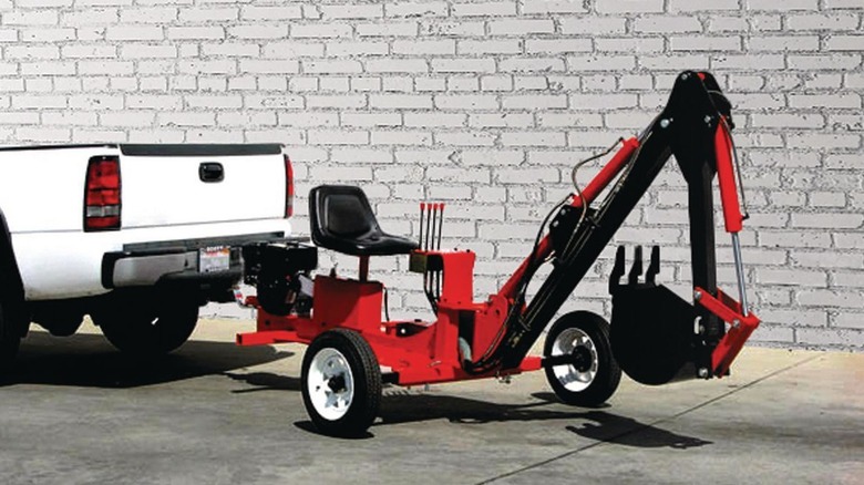 towable backhoe hitched to a pickup truck 