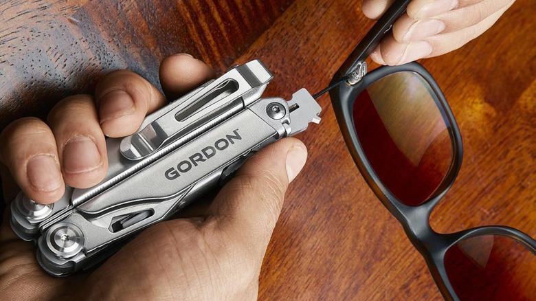 Person using multi-tool to fix sunglasses