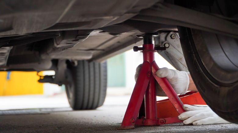 Jack stand being used to hold up car