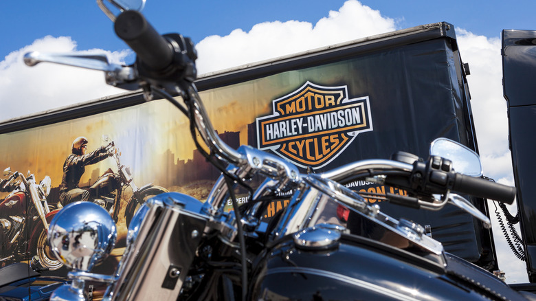 A motorcycle parked in front of a Harley-Davidson logo.