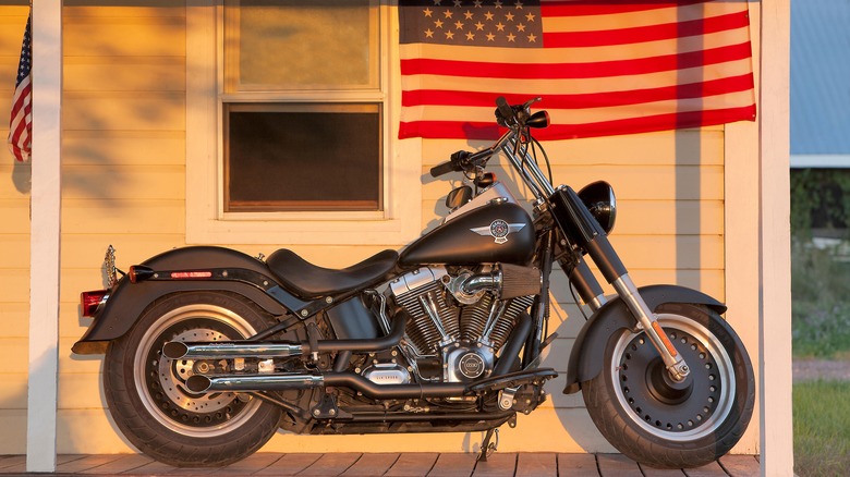 A Fat Boy parked outside a building in the evening