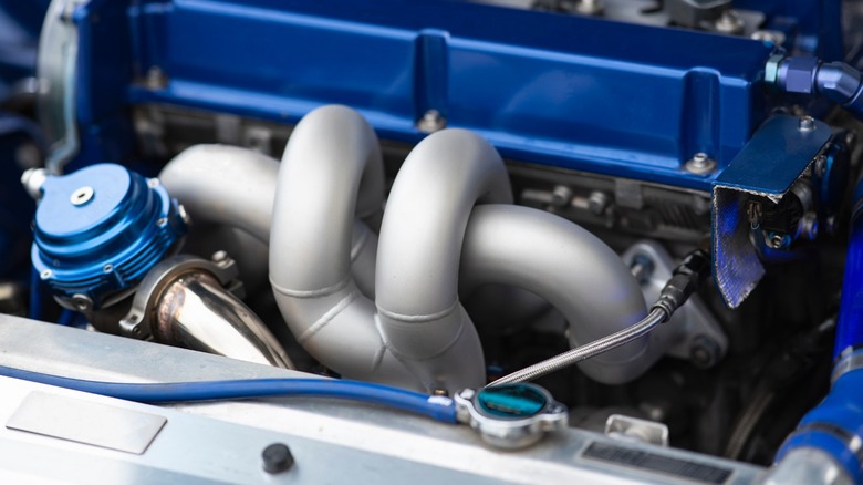 custom exhaust manifold installed on a blue engine