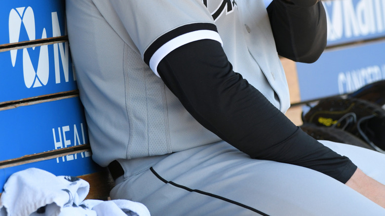 A sportsman massages his arm with a Therabody Theragun