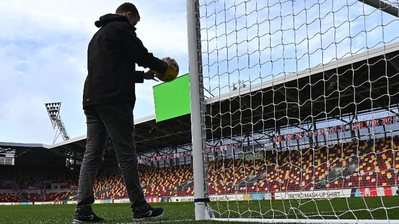 Holding a soccer ball at the goal line