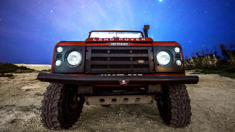 front of a Land Rover at night