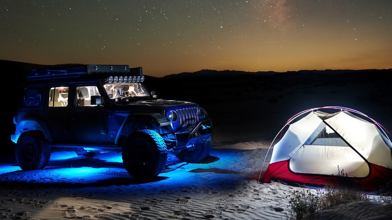 vehicle with blue rock lights next to camping tent