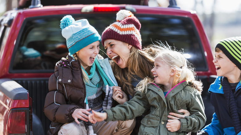 A Mother And Three Children In A Pickup Truck Bed