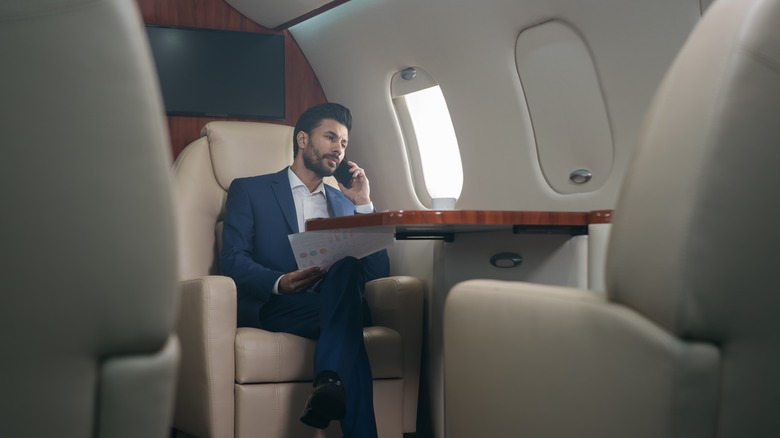 Man talks on the phone in a private jet