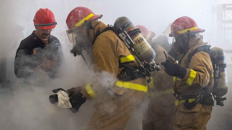 Four firefighters conducting training in smokey conditions