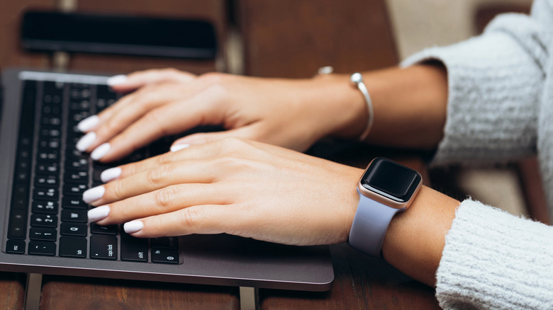 woman's fingers on MacBook keyboard