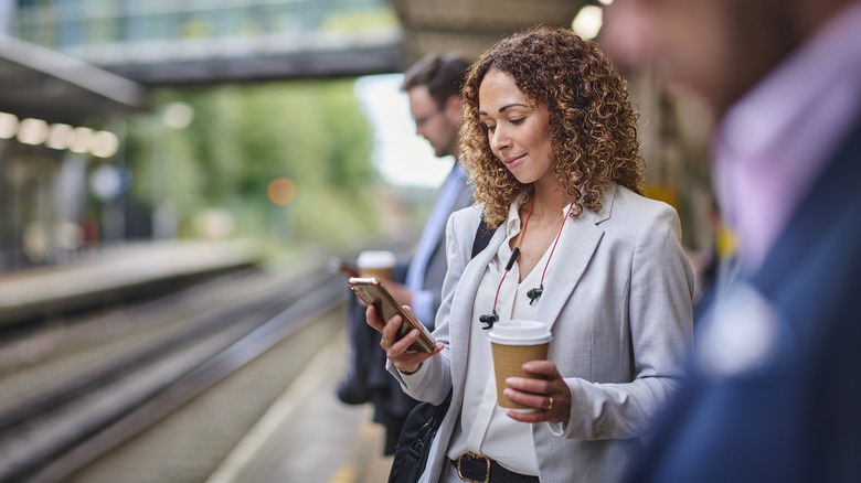 looking at phone at train station