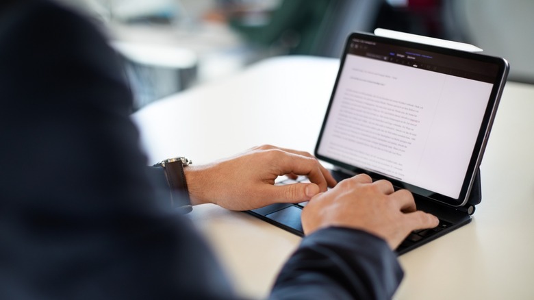 a person typing on an iPad