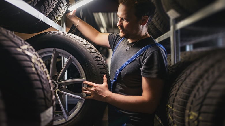 A person handling tires.