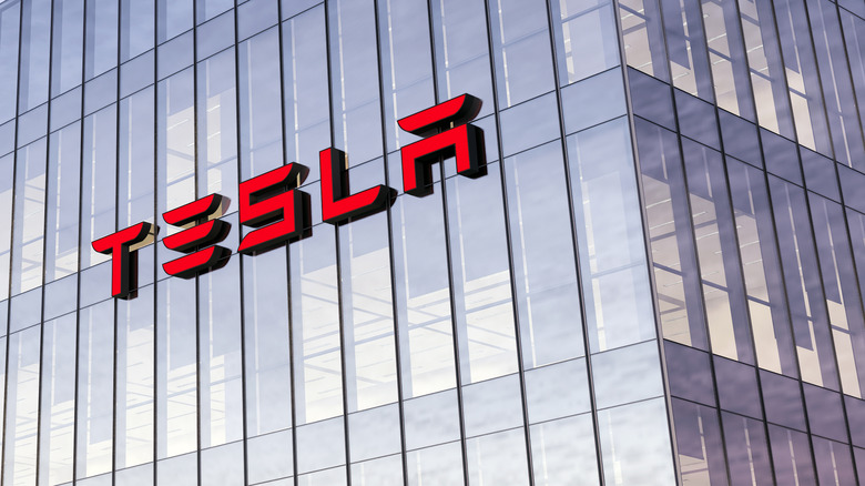 The Tesla logo seen on a glass facade.