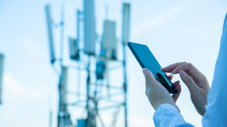 Person using phone cell tower