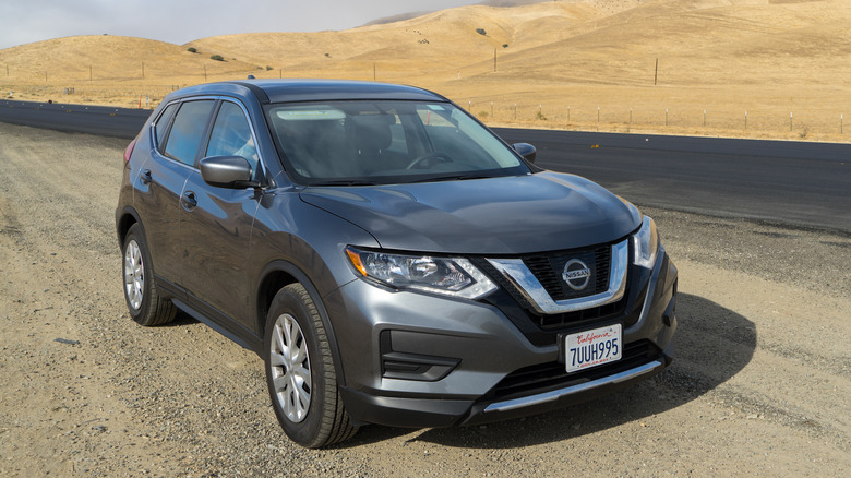 Gray Nissan Rogue on side of the road