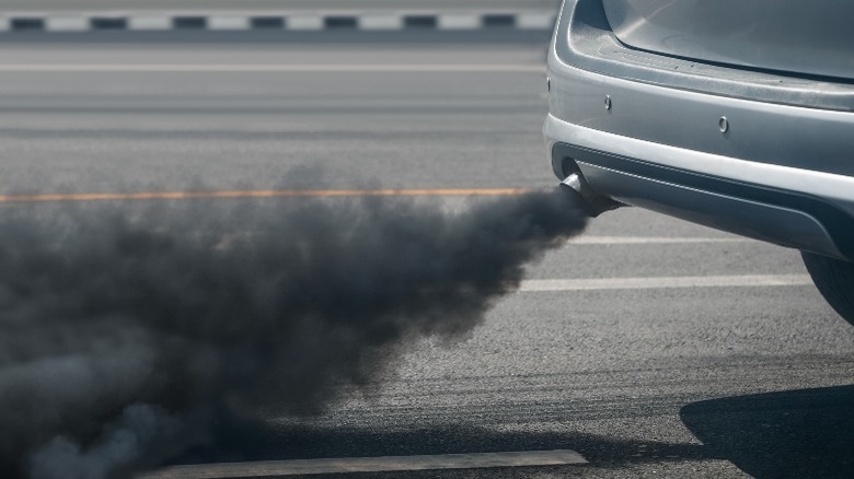 Car on the road expelling black smoke from exhaust