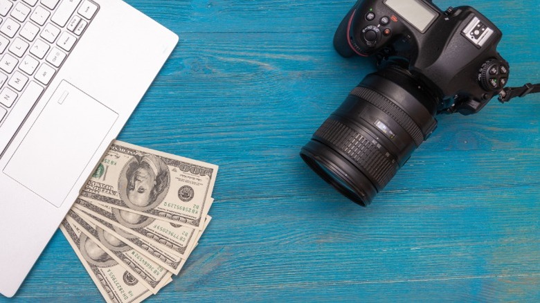 DSLR camera next to cash