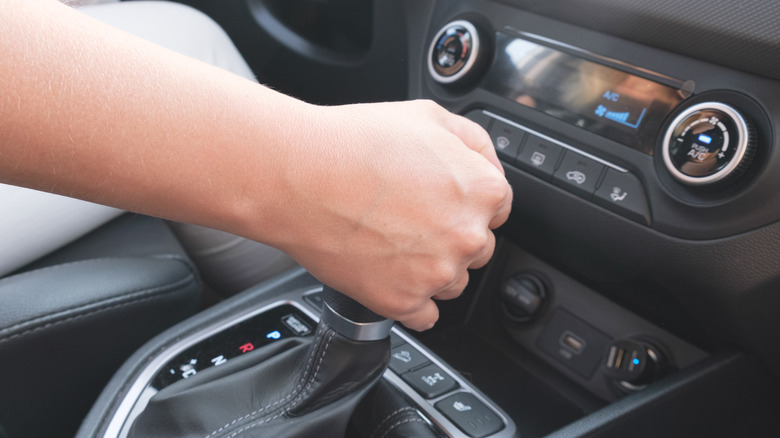 Driver shifting the automatic gearbox of a car