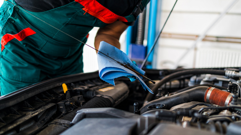 mechanic working under car hood