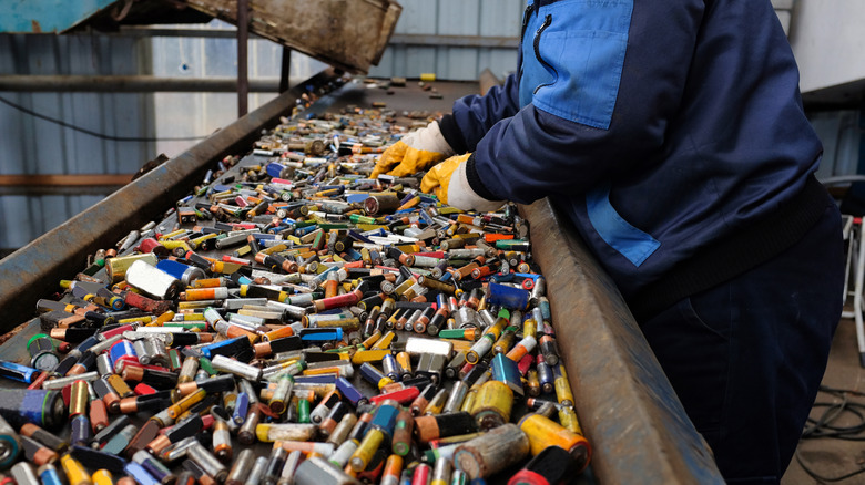 A worker sorts batteries in a recycling plant