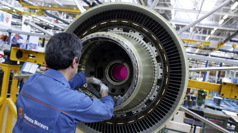 Person working on GE-90 turbine engine