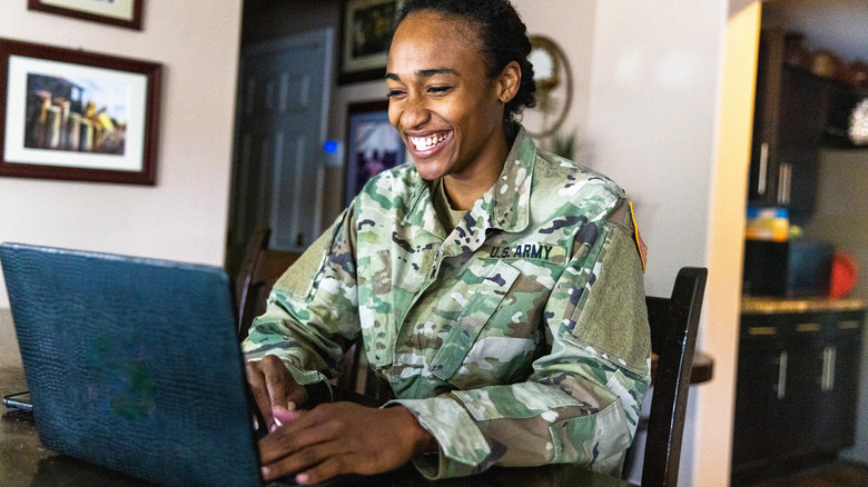 Soldier smiling working on laptop