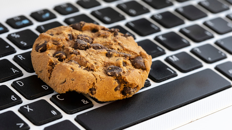 a chocolate chip cookie on a computer keyboard
