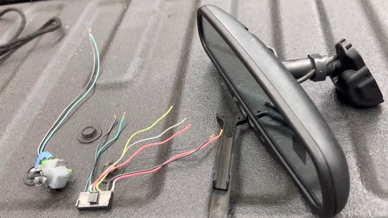 Rear view mirror wiring components laid out on a truck bed.