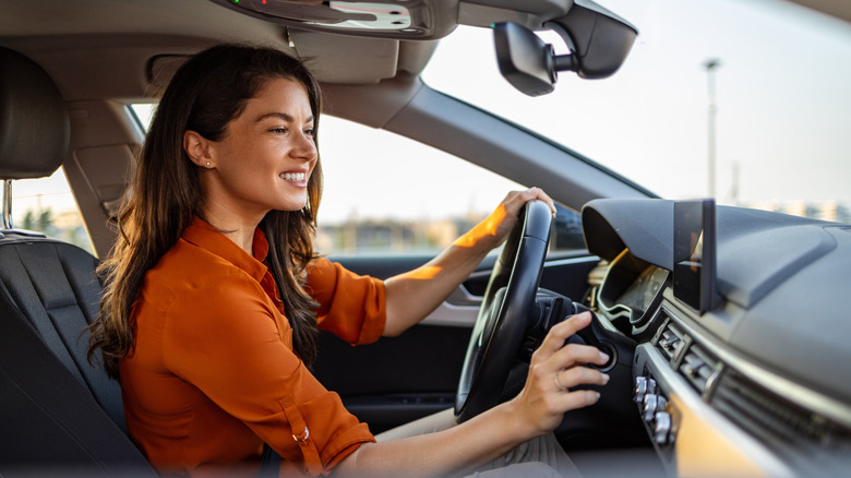 Woman adjusting controls on steering wheel stalk