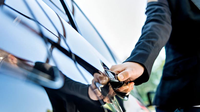 Man in suit opening car door