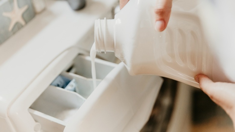 Pouring detergent into a washing machine