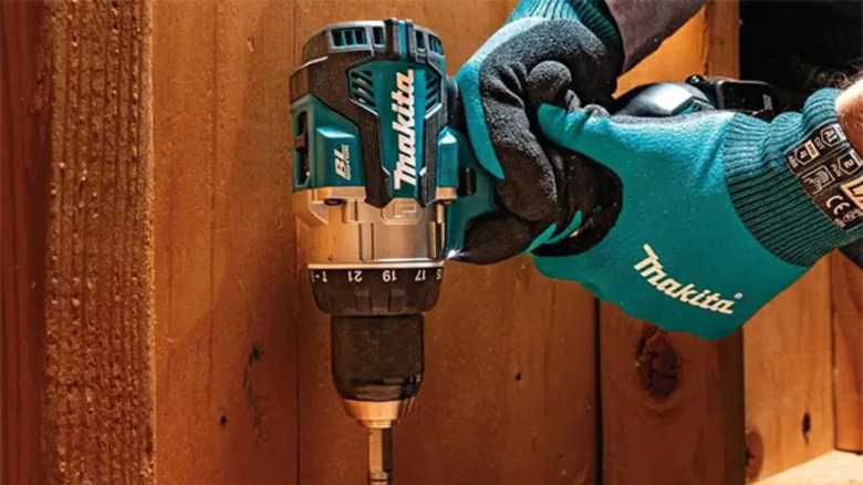 Person wearing Makita gloves using drill