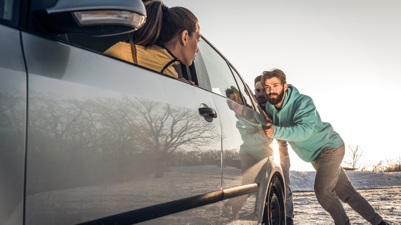 Two men pushing car