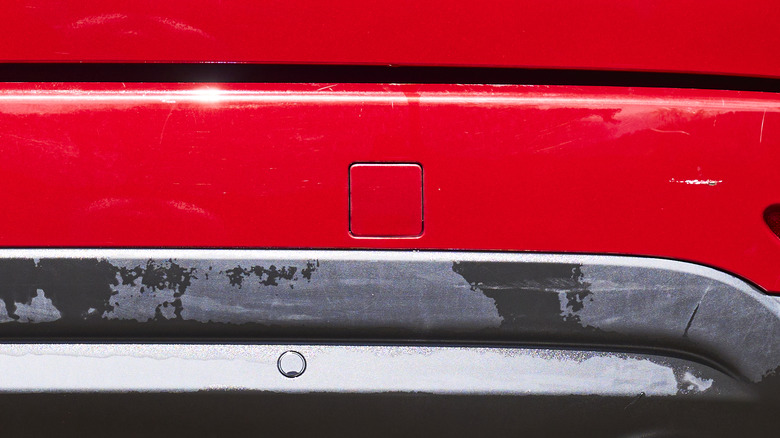 A covered trailer hookup on the bumper of an SUV.