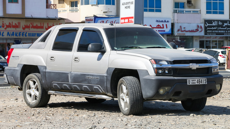 Grey First-gen Chevy Avalanche parked in rocky dirt lot