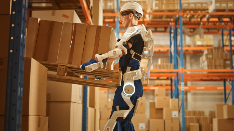 Person in exoskeleton lifting packages