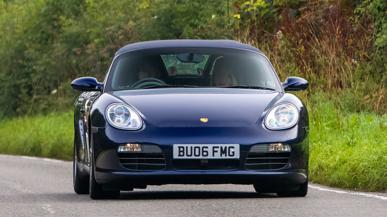 Blue Porsche Boxster on country road