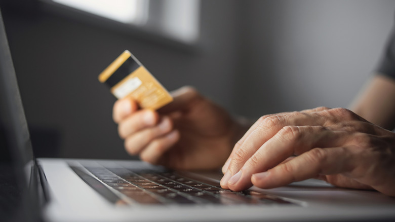 Using a laptop while holding a credit card