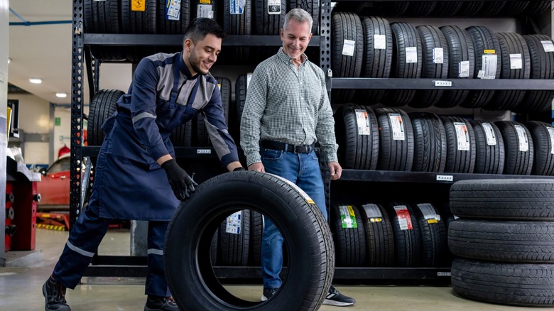 Mechanic wheeling a tire