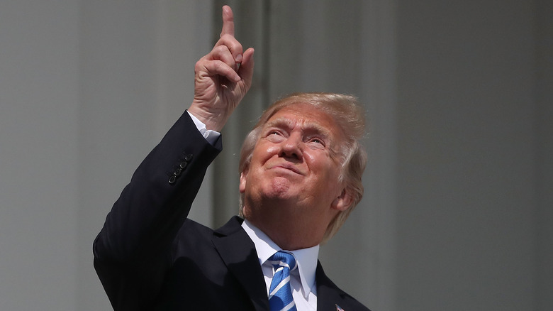 Donald Trump looking at eclipse