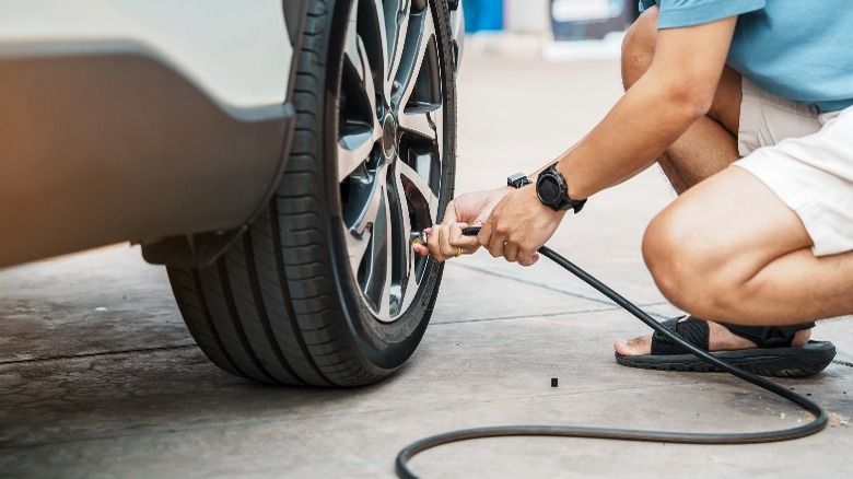 Person inflating a tire