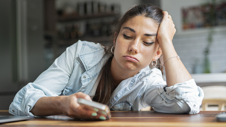 frowning woman using iphone