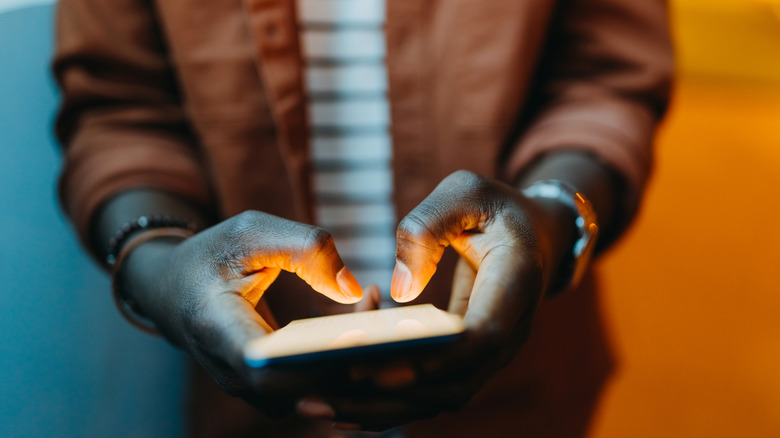 person typing on smartphone bright display