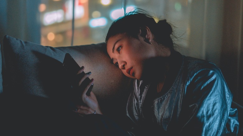 Asian woman using a smartphone in the dark.