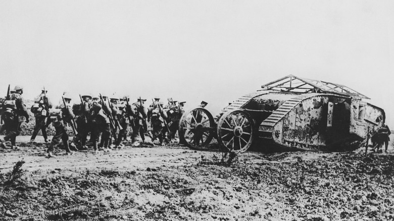 British infantry walking behind a British Mark I on way to Front Line, 1918.